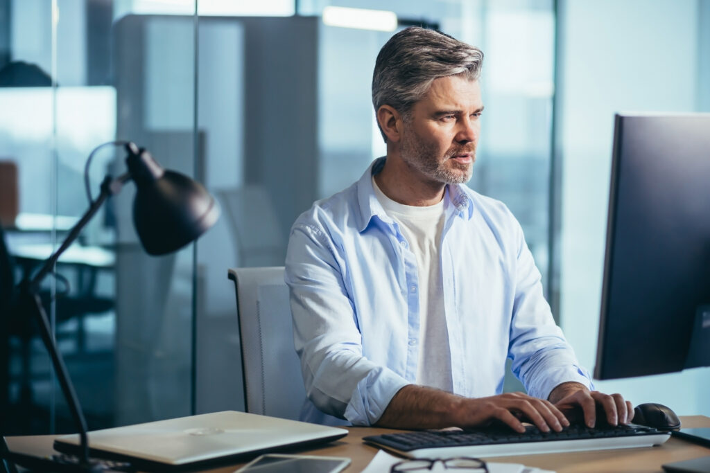 Grey Haired man at computer